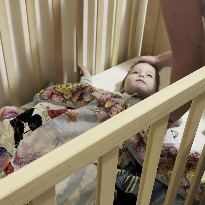 Baby sleeping peacefully in darkened nursery with My Blackout Blind